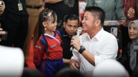 Gubernur Herman Deru bersama salah seorang anak di acara Peringatan puncak Hari Anak Nasional (HAN) ke-41 tahun 2025 di Taman Purbakala Kerajaan Sriwijaya (TPKS), Palembang, Senin (11/8/2025). foto humas